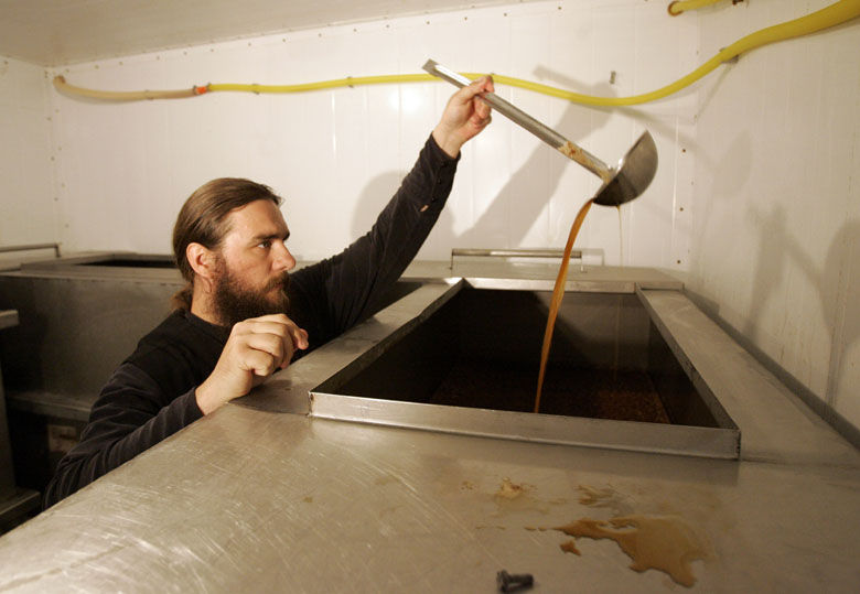 Orthodox priest, Father Antony, tests the ancient Russian fermented-bread drink known as kvas in a basement of the fifteenth-century Savvino-Storozhevsky Orthodox Monastery in Zvenigorod, 35 miles west of Moscow, Russia, Tuesday, July 1, 2008. For over 600 years, monks at the Savvino-Storozhevsky Monastery have been brewing kvas for themselves, and seven years ago began selling it. Unlike mass-produced varieties, the monastery's kvas has no preservatives and spoils within five days. (AP Photo/Dmitry Lovetsky)