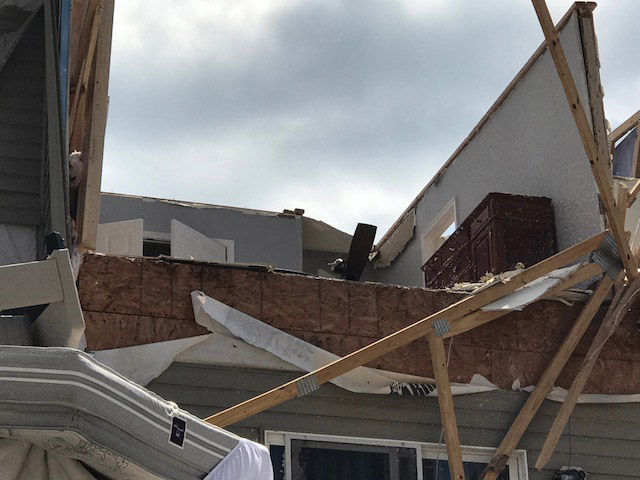 A dresser can be seen on the upper story of a townhome damaged during a violent storm in Stevensville, Maryland, on Monday, July 24, 2017. (WTOP/Steve Dresner)