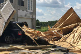 A truck lies buried beneath pieces of roofing and the remnants of a porch in Stevensville, Maryland on Monday, July 24, 2017. Federal officials surveyed damage from the overnight storm to determine if a tornado was the cause. (WTOP/Steve Dresner)