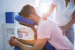 Physiotherapist giving back massage to a patient in clinic