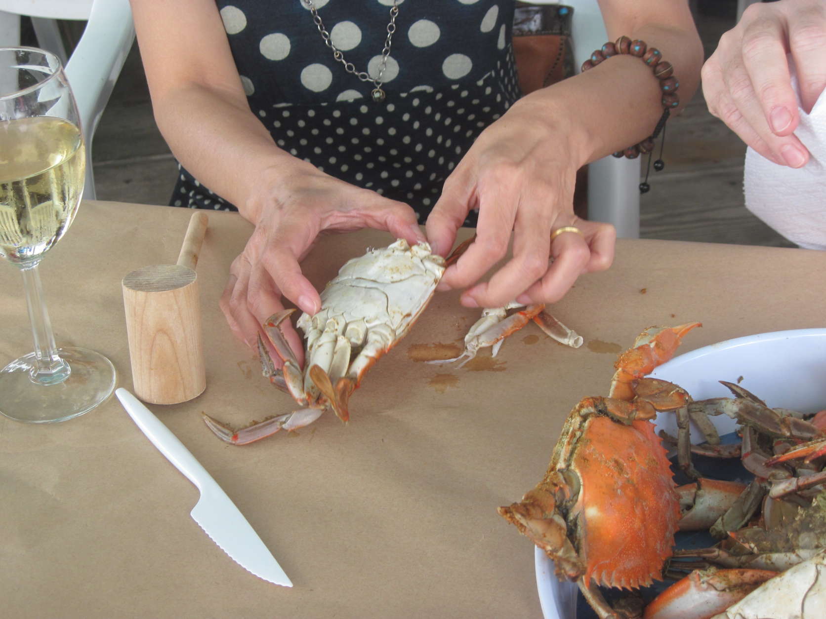 Photo shows a woman picking steamed crabs