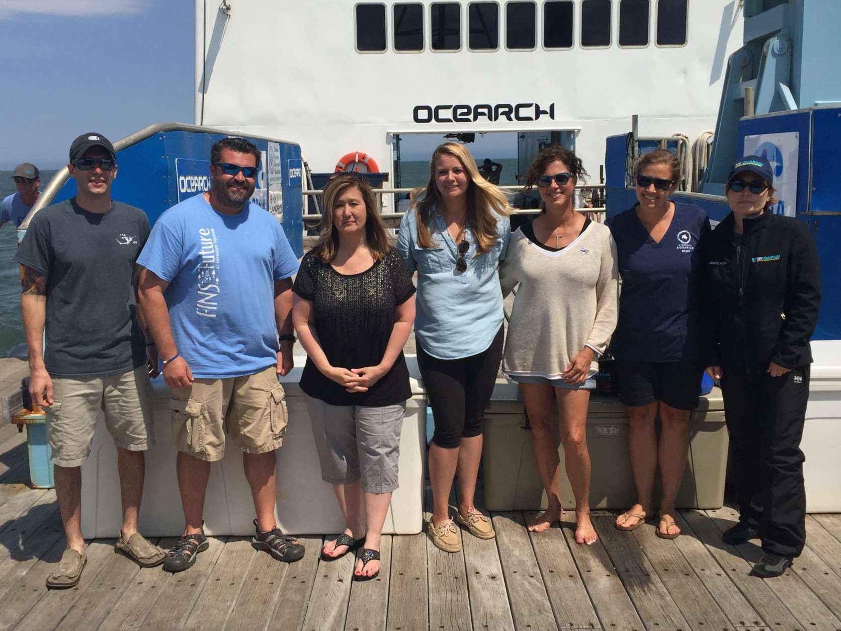 A group of researchers and guests pose for a photo aboard the OCEARCH. (WTOP/Michelle Basch)