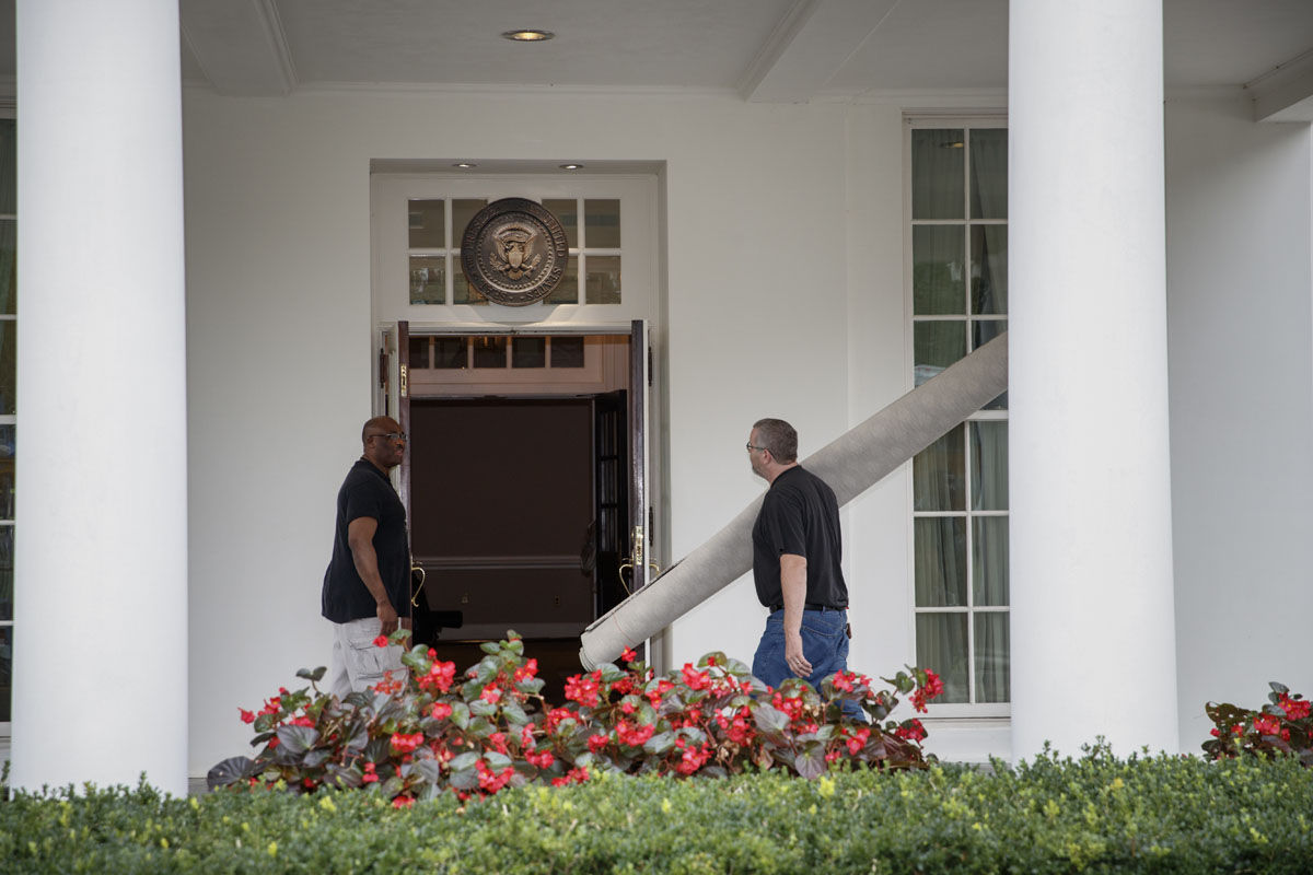Workmen carry carpet into the West Wing of the White House in Washington, Friday, Aug. 11, 2017, during renovations while President Donald Trump is spending time at his golf resort in New Jersey. (AP Photo/J. Scott Applewhite)