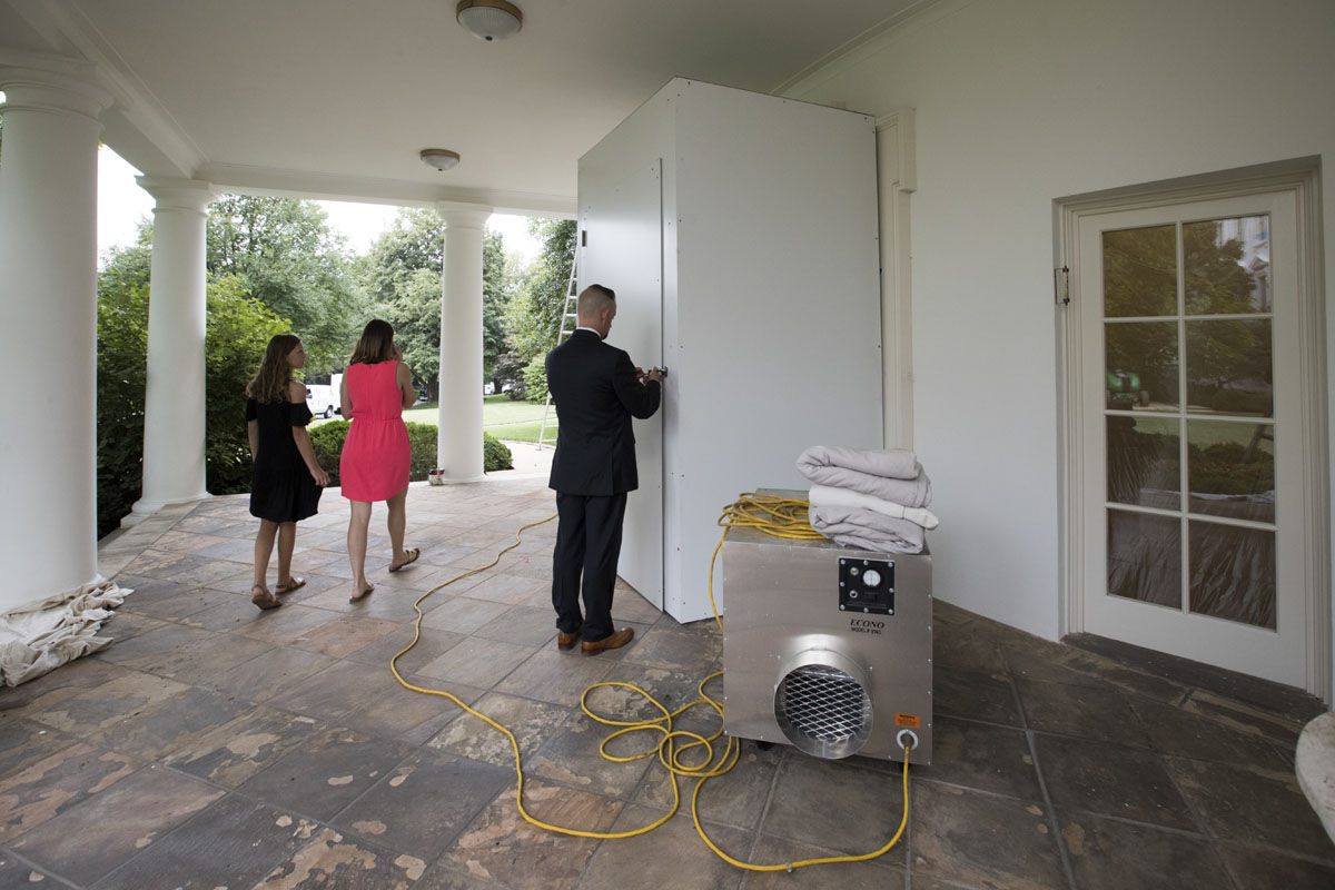 A Secret Service agent unlocks a service entrance to the Oval Office as the West Wing of the White House in Washington, Friday, Aug. 11, 2017,  as renovations continue while President Donald Trump is spending time at his golf resort in New Jersey. (AP Photo/J. Scott Applewhite)