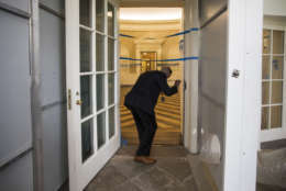 A Secret Service agent checks on the Oval Office of the White House in Washington, Friday, Aug. 11, 2017, as the West Wing of the White House in Washington is undergoing renovations while President Donald Trump is spending time at his golf resort in New Jersey. (AP Photo/J. Scott Applewhite)
