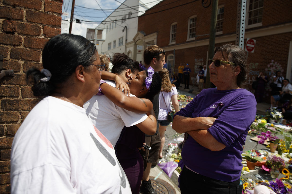People gather near a memorial for Heather Heyer, who was killed during a white nationalist rally, after a service to honor her life, Wednesday, Aug. 16, 2017, in Charlottesville, Va. (AP Photo/Evan Vucci)