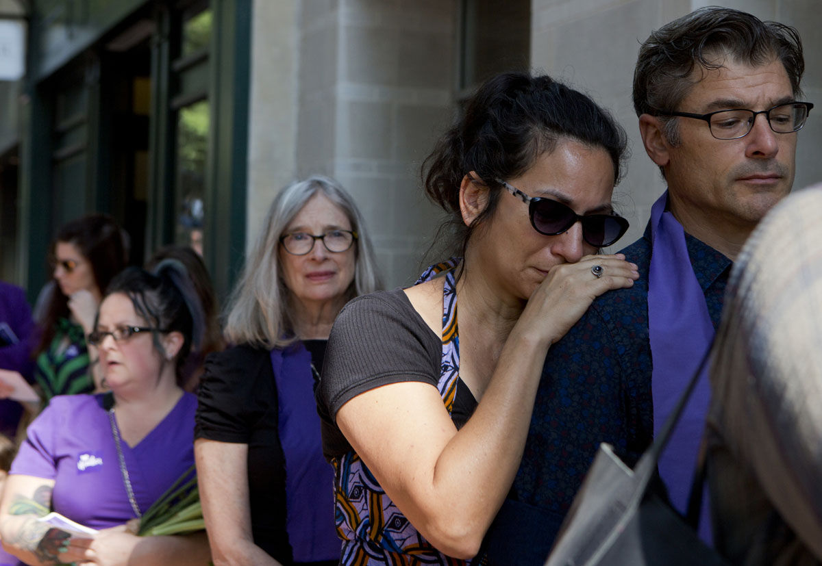 April Muniz cries on Tom Clay's shoulder as they wait to enter a memorial service for Heather Heyer, Wednesday, Aug. 16, 2016 in Charlottesville, Va.  Heyer was killed Saturday, when a car rammed into a crowd of people protesting a white nationalist rally.  "I was there," Muniz said. (AP Photo/Julia Rendleman)