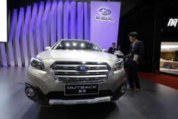 A man looks at the Subaru Outback SUV   during the Auto Shanghai 2017 show at the National Exhibition and Convention Center in Shanghai, China, Thursday, April 20, 2017.  Models on display at Auto Shanghai 2017, the global industry's biggest marketing event of the year, reflect the conflict between Beijing's ambitions to promote environmentally friendly propulsion and Chinese consumers' love of hulking, fuel-hungry SUVs.  (AP Photo/Ng Han Guan)