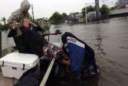 Rhonda Worthington is lifted into a boat while on her cell phone with a 911 dispatcher after her car become stuck in rising floodwaters from Tropical Storm Harvey in Houston, Texas, Monday, Aug. 28, 2017. (AP Photo/LM Otero)