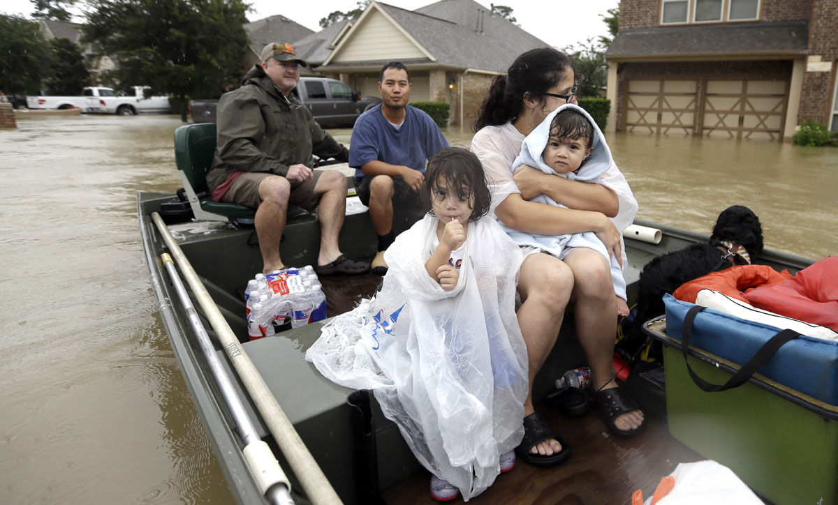 A family is evacuated from their home as floodwaters from Tropical Storm Harvey rise Monday, Aug. 28, 2017, in Spring, Texas. (AP Photo/David J. Phillip)