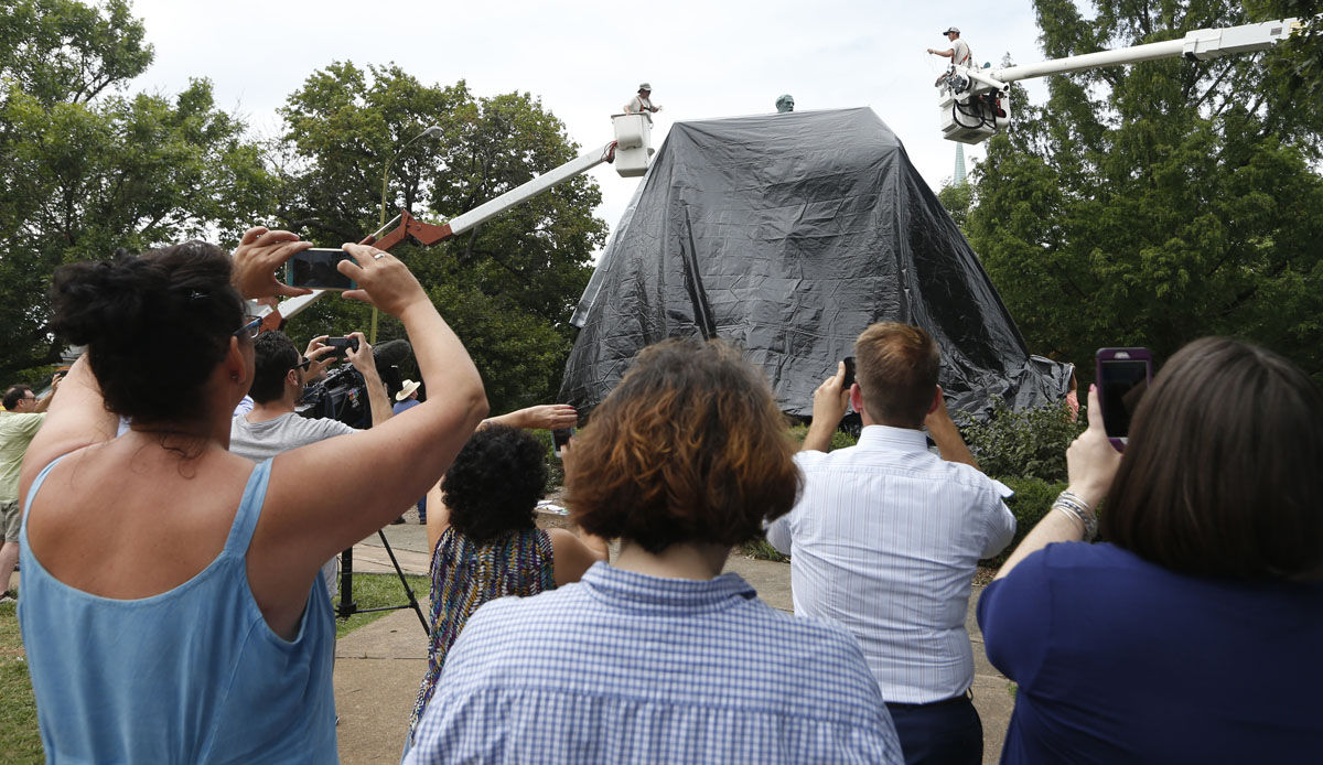 Charlottesville residents take photos of city workers as they drape a tarp over the statue of Confederate General Robert E. Lee in Emancipation park in Charlottesville, Va., Wednesday, Aug. 23, 2017. The move intended to symbolize the city's mourning for a woman killed while protesting a white nationalist rally earlier this month. (AP Photo/Steve Helber)