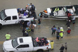 Evacuees are helped as floodwaters from Tropical Storm Harvey rise Tuesday, Aug. 29, 2017, in Houston. (AP Photo/David J. Phillip)