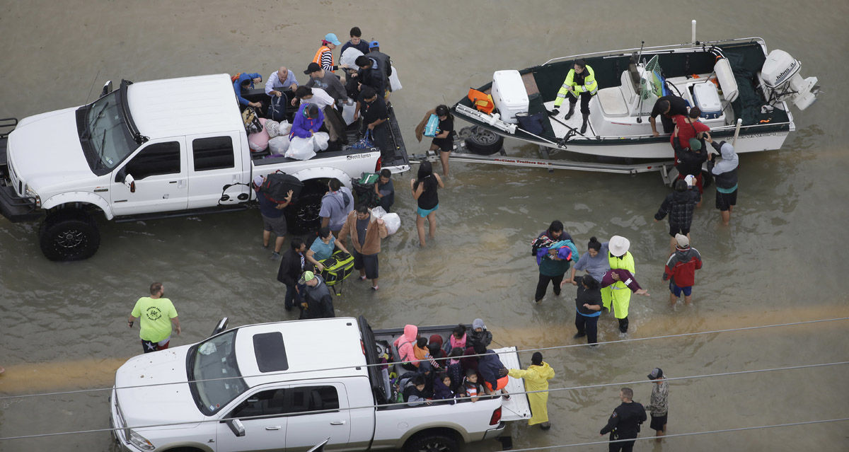 Evacuees are helped as floodwaters from Tropical Storm Harvey rise Tuesday, Aug. 29, 2017, in Houston. (AP Photo/David J. Phillip)
