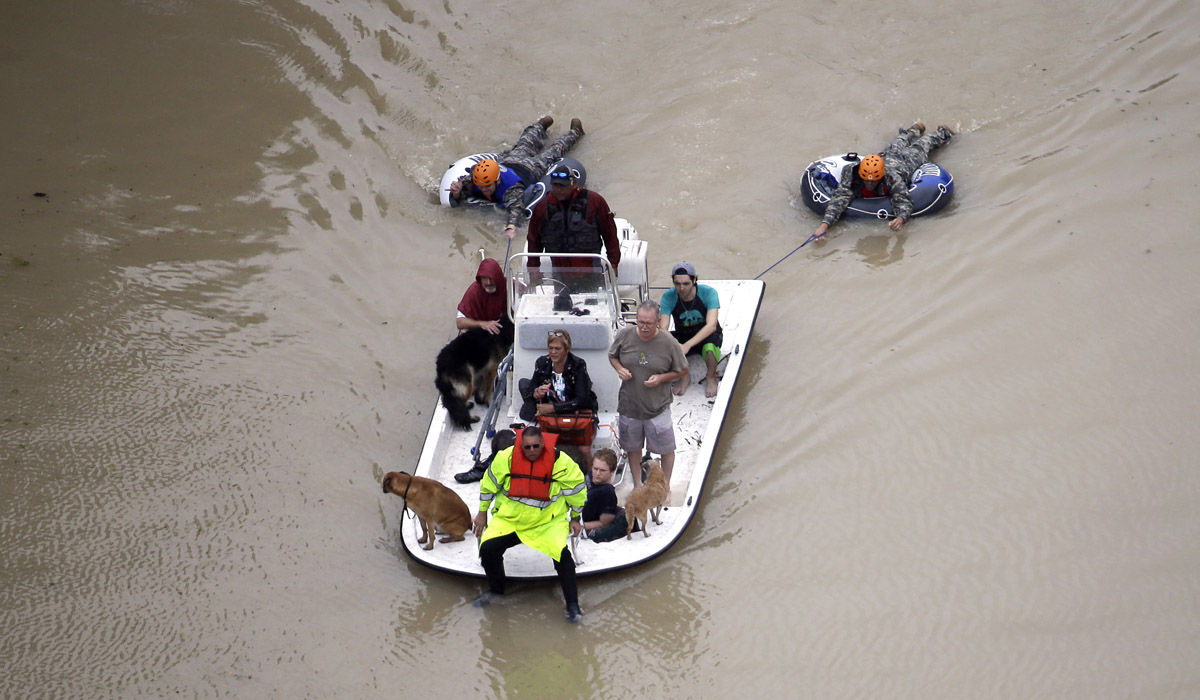 Evacuees make their way though floodwaters near the Addicks Reservoir as floodwaters from Tropical Storm Harvey rise Tuesday, Aug. 29, 2017, in Houston. (AP Photo/David J. Phillip)