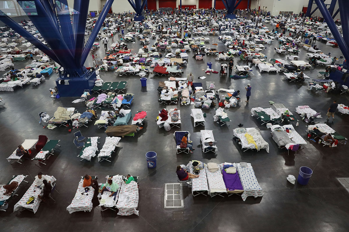 HOUSTON, TX - AUGUST 29:  People take shelter at the George R. Brown Convention Center after flood waters from Hurricane Harvey inundated the city on August 29, 2017 in Houston, Texas. The evacuation center which is overcapacity has already received more than 9,000 evacuees with more arriving.  (Photo by Joe Raedle/Getty Images)