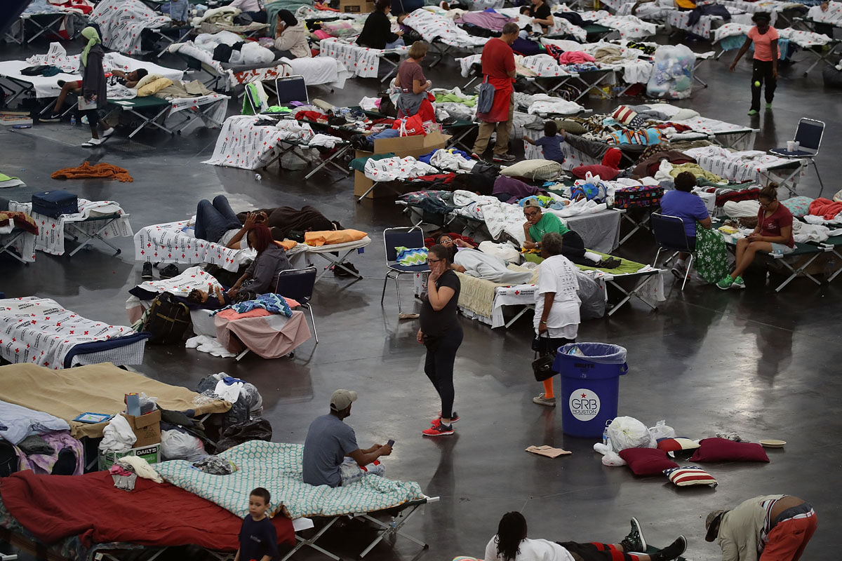 HOUSTON, TX - AUGUST 29:  People take shelter at the George R. Brown Convention Center after flood waters from Hurricane Harvey inundated the city on August 29, 2017 in Houston, Texas. The evacuation center which is overcapacity has already received more than 9,000 evacuees with more arriving.  (Photo by Joe Raedle/Getty Images)