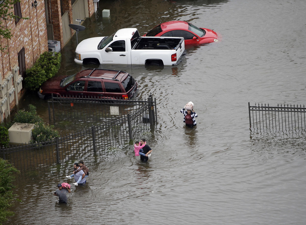Residents wade through floodwaters as they evacuate their homes near the Addicks Reservoir as floodwaters from Tropical Storm Harvey rise Tuesday, Aug. 29, 2017, in Houston. (AP Photo/David J. Phillip)
