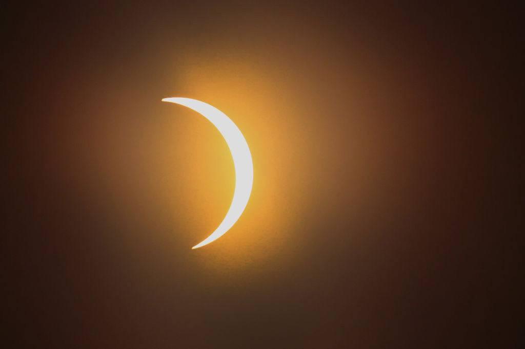 CARBONDALE, IL - AUGUST 21:  The moon eclipses the sun above the campus of Southern Illinois University on August 21, 2017 in Carbondale, Illinois. Although much of it was covered by a cloud, with approximately 2 minutes 40 seconds of totality the area in Southern Illinois experienced the longest duration of totality during the eclipse. Millions of people are expected to watch as the eclipse cuts a path of totality 70 miles wide across the United States from Oregon to South Carolina on August 21.  (Photo by Scott Olson/Getty Images)