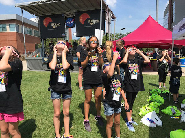 Kids in Carbondale, Illinois look up to the sky ahead of the solar eclipse. (WTOP/Steve Dresner)