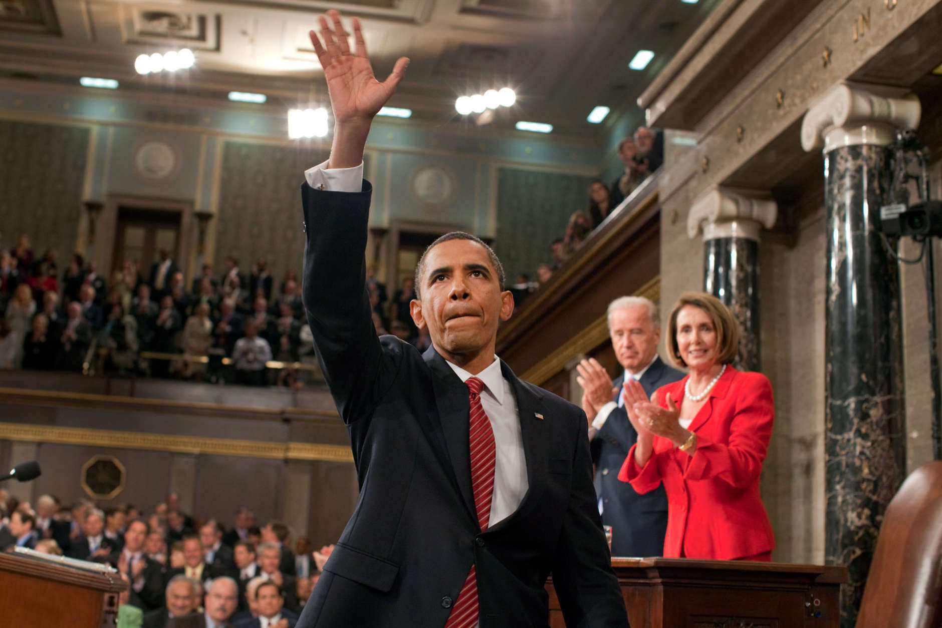 President Barack Obama waves to the First Lady and guests seated in the gallery of the House Chamber at the U.S. Capitol in Washington, D.C., Sept. 9, 2009. IN the background are Vice President Joe Biden and Speaker of the House Nancy Pelosi. (Official White House Photo by Pete Souza) 