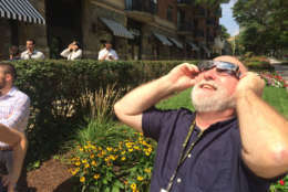 Michael O'Connell, Senior Digital Editor at Federal News Radio, gets a glimpse of the eclipse. (WTOP/Sarah Beth Hensley)
