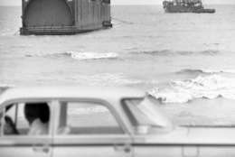 A large tugboat tied onto the 286-foot steel tunnel liner that beached itself near the seawall in Galveston, Texas on Wednesday, Sept. 15, 1961. Two of the huge liners were being towed from Orange, Tex., to Norfolk, Va., for use on a Chesapeake Bay bridge-tunnel, when the tug ran into high seas kicked by hurricane Carla. This one apparently floated 270-miles after breaking loose. (AP Photo/Ed Kolenovsky)