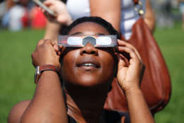 Esther Owolabi looks up at the sky at the solar eclipse. (WTOP/Kate Ryan)