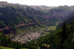 The old mining town of Telluride, Colo., is pictured nestled in a vally from the top of Mount St. Sophia on July 17, 2001. Telluride has reached a crossroads, the question now being whether the town should build on its appeal to the rich by developing its lush, 880-acre valley floor. (AP Photo/Ed Andrieski)