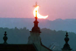The sun is seen behind a tower of a Prague's church during a partial solar eclipse at dawn on Saturday, May 31, 2003. (AP Photo/CTK, Ivan Vetvicka)