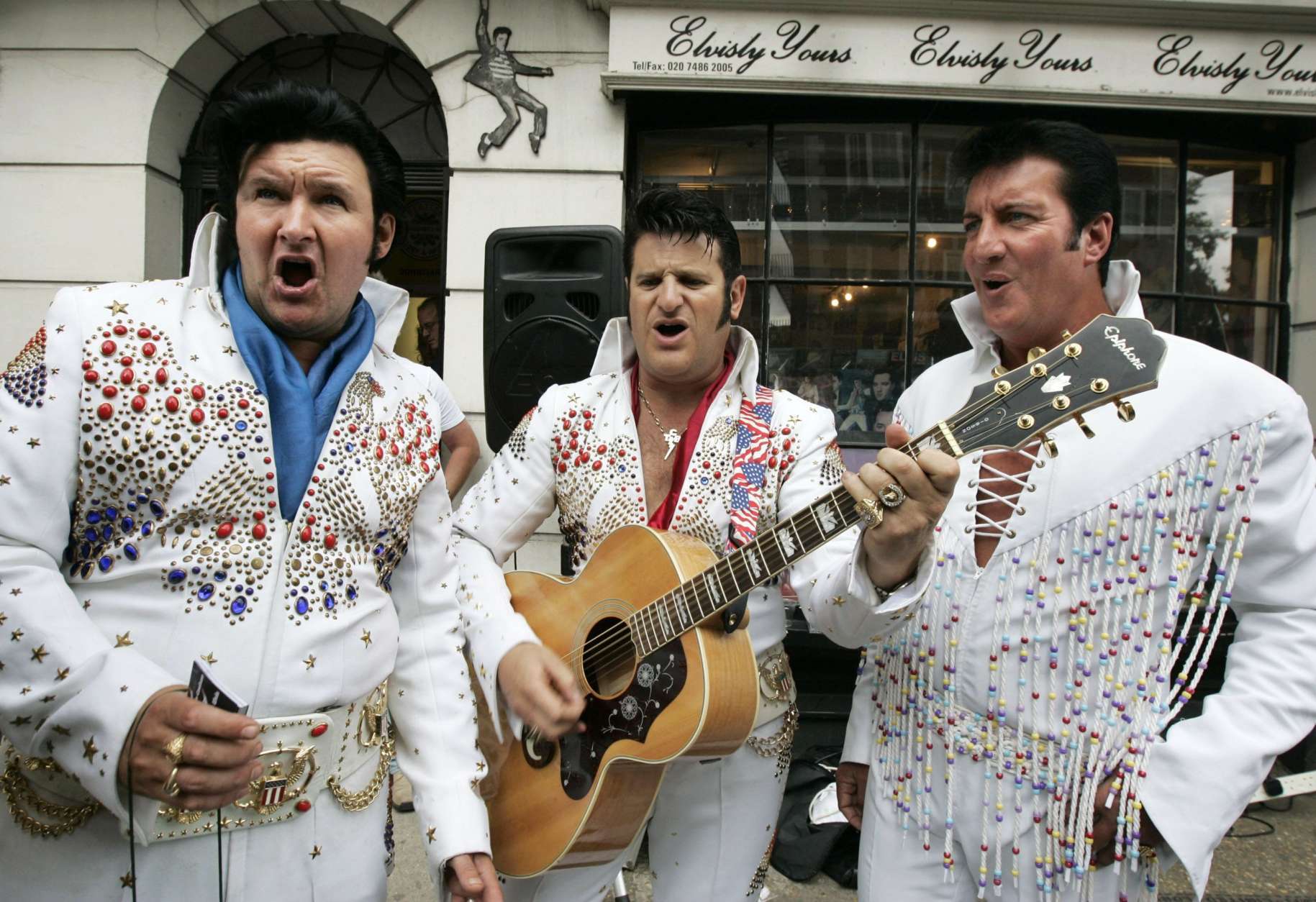 British Elvis Presley impersonators, from left to right, Ian Coulson, Elvis Shmelvis and Gary King, perform during an event outside a rock memorabilia shop in central London to mark the anniversary of the singer's death, Thursday Aug. 16, 2007. The event to mark 30 years since the death of Elvis also raised money for a local charity. (AP Photo/Lefteris Pitarakis)