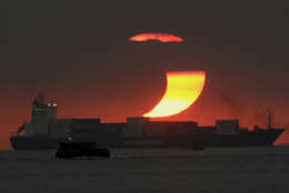 The moon cast a shadow at the sun blocking it partially in a partial solar eclipse as it sets on Monday Jan. 26, 2009 at Manila's bay, Philippines. (AP Photo/Aaron Favila)