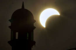 A partial solar eclipse is seen near the minaret of a mosque in Rawalpindi, Pakistan on Wednesday, July 22, 2009. The longest solar eclipse of the 21st century pitched a swath of Asia from India to China into near darkness Wednesday as millions gathered to watch the phenomenon. (AP Photo/Anjum Naveed)