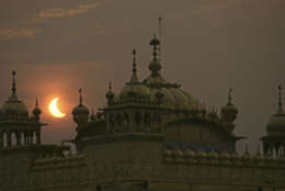 A partial solar eclipse is seen behind the Golden Temple, Sikhs holiest shrine, in Amritsar, India, Wednesday, July 22, 2009. Millions of Asians turned their eyes skyward Wednesday as dawn suddenly turned to darkness across the continent in the longest total solar eclipse this century will see. Millions of others, seeing the rare event as a bad omen, shuttered themselves indoors. (AP Photo/Altaf Qadri)