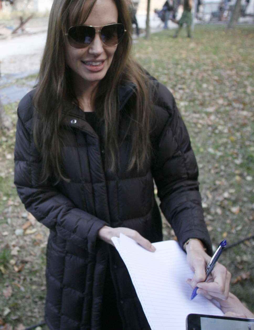 FILE - US actress Angelina Jolie signs autographs for fans during the shooting of her directorial debut, a film called 'Untitled Bosnian War Love Story' in Budapest, Hungary, in this Wednesday, Oct. 13, 2010 file photo. Bosnian authorities have denied Jolie a permit to shoot her directorial film debut in the country amid protests by rape victims who object to its alleged subject matter. J olie's Sarajevo  producer, Edin Sarkic,  said  Friday  Oct 15 2010 that the rumors were not true. He says he has re-submitted the application and sent the film's full script to Sarajevo's  Culture Minister and expects to get a permit. (AP Photo/MTI, Bea Kallos, Pool, file)