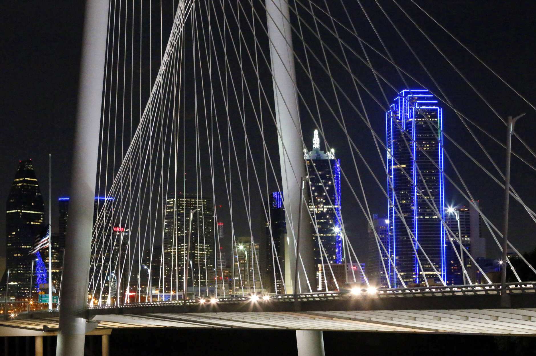 The Dallas city skyline is seen through the Margaret Hunt Hill Bridge, Saturday, July 9, 2016, in Dallas. Many of the cities buildings and structures are highlighted in blue as a tribute to the several police officers that were killed and others injured in a attack Thursday night by gunman Micah Johnson. (AP Photo/Tony Gutierrez)
