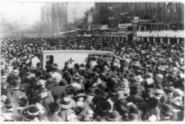 In this photo provided by the Library of Congress, taken in 1913, a crowd gathers around a Red Cross ambulance during the women's suffrage procession in Washington. Thousands of women take to the streets of Washington, demanding a greater voice for women in American political life as a new president takes power. This will happen on Saturday, Jan. 21, 2017, one day after the inauguration of Donald Trump. This DID happen more than 100 years ago, one day before the inauguration of Woodrow Wilson. (Library of Congress via AP)