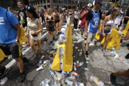 Festival goers walk towards the entrance as plastic bottle and cups are left in front of the gate at Lollapalooza, Thursday, Aug. 3, 2017, in Chicago. Festival goers are not allowed to bring in any open bottles. (AP Photo/G-Jun Yam)