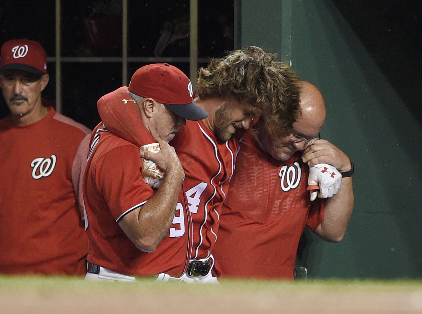 Washington Nationals' Bryce Harper, center, is helped in the dugout after he was injured during the first inning of the team's baseball game against the San Francisco Giants, Saturday, Aug. 12, 2017, in Washington. (AP Photo/Nick Wass)