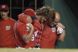 Washington Nationals' Bryce Harper, center, is helped in the dugout after he was injured during the first inning of the team's baseball game against the San Francisco Giants, Saturday, Aug. 12, 2017, in Washington. (AP Photo/Nick Wass)