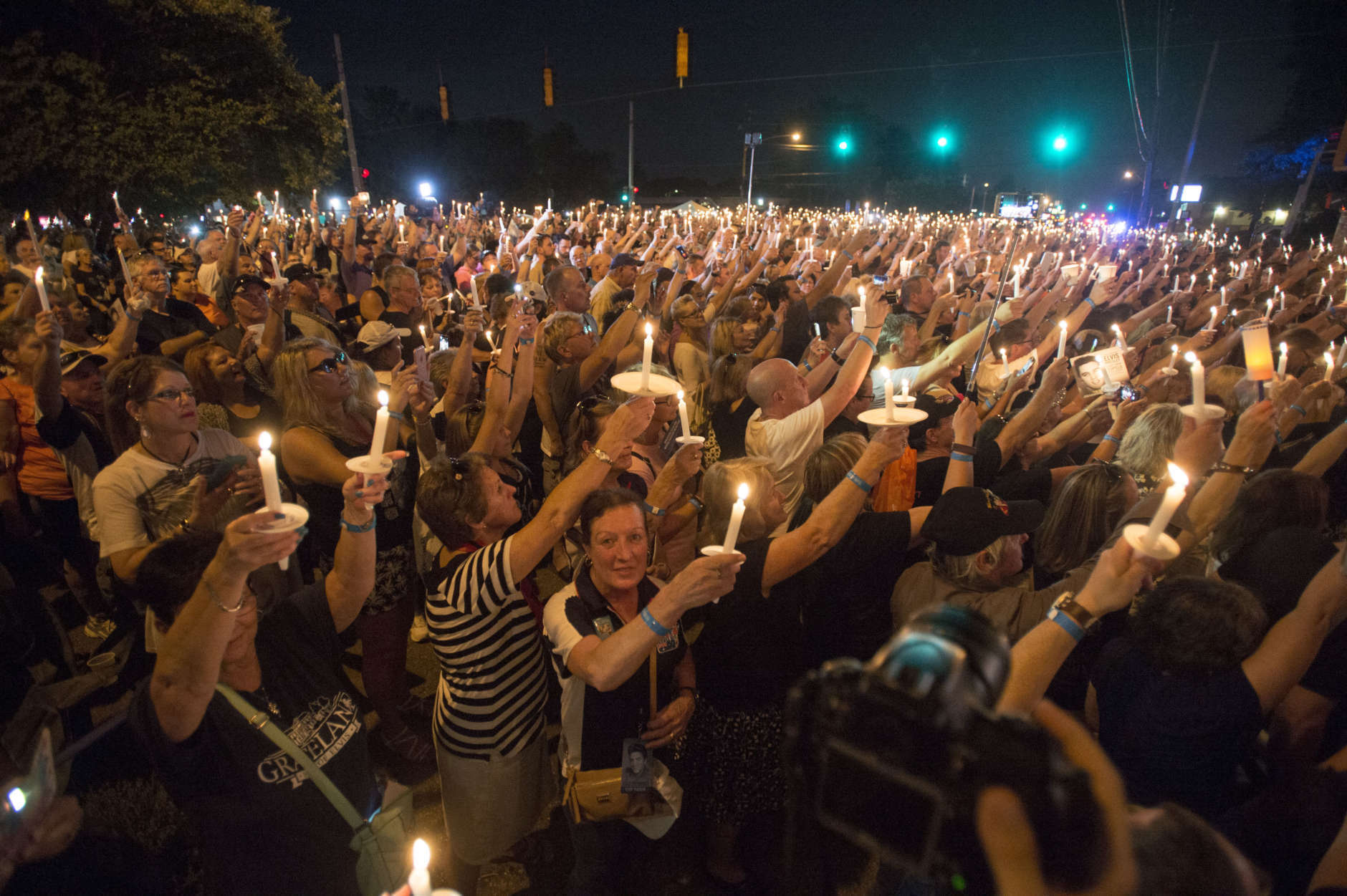 Fans hold candles during a vigil for Elvis Presley at Graceland, Presley's Memphis home, Tuesday, Aug. 15, 2017, in Memphis, Tenn. Fans from around the world are at Graceland for the 40th anniversary of his death. Presley died Aug. 16, 1977. (AP Photo/Brandon Dill)