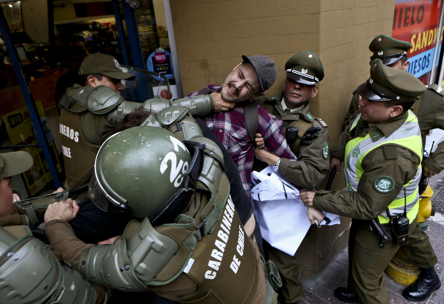A man is detained by national police outside the Argentina consulate during a protest demanding information on the whereabouts of missing activist Santiago Maldonado, in Santiago, Chile, Thursday, Aug. 17, 2017. Maldonado’s family says he went missing Aug. 1, when he was taking part in a protest supporting the land claims by the indigenous Mapuche community. They say border police detained him when he was blocking a road with other protesters in Chubut province, about 1,100 miles (1,800 kilometers) southeast of Argentina’s capital. (AP Photo/Esteban Felix)