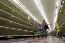 Shoppers pass empty shelves along the bottled water aisle in a Houston grocery store as Hurricane Harvey intensifies in the Gulf of Mexico, Thursday, Aug. 24, 2017. Harvey is forecast to be a major hurricane when it makes landfall along the middle Texas coastline. (AP Photo/David J. Phillip)