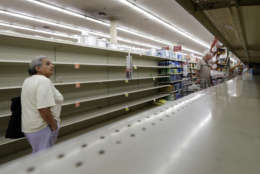 Shoppers pass empty shelves along the bottled water aisle in a Houston grocery store as Hurricane Harvey intensifies in the Gulf of Mexico, Thursday, Aug. 24, 2017. Harvey is forecast to be a major hurricane when it makes landfall along the middle Texas coastline. (AP Photo/David J. Phillip)