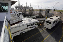Vehicles and RVs drive off a ferry as they depart Port Aransas, Texas, after a mandatory evacuation was ordered in preparation for Hurricane Harvey, Thursday, Aug. 24, 2017. Harvey intensified into a hurricane Thursday and steered for the Texas coast. (AP Photo/Eric Gay)