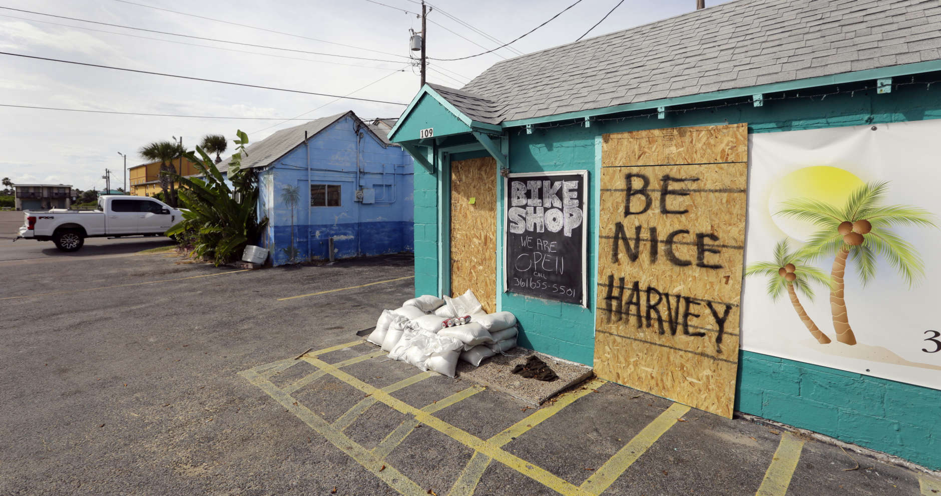 A sign reading "Be Nice Harvey" was left behind on a boarded up business, Thursday, Aug. 24, 2017, in Port Aransas, Texas. Port Aransas is under a mandatory evacuation for Hurricane Harvey. Harvey intensified into a hurricane Thursday and steered for the Texas coast. (AP Photo/Eric Gay)