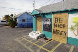 A sign reading "Be Nice Harvey" was left behind on a boarded up business, Thursday, Aug. 24, 2017, in Port Aransas, Texas. Port Aransas is under a mandatory evacuation for Hurricane Harvey. Harvey intensified into a hurricane Thursday and steered for the Texas coast. (AP Photo/Eric Gay)
