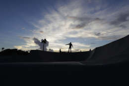 Jake High rides his skateboard at sunset, Thursday, Aug. 24, 2017, in Corpus Christi, Texas. Harvey intensified into a hurricane Thursday and steered for the Texas coast with the potential for up to 3 feet of rain, 125 mph winds and 12-foot storm surges in what could be the fiercest hurricane to hit the United States in almost a dozen years. (AP Photo/Eric Gay)