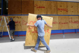 James Redford carries a sheet of plywood as he helps board up windows in preparation for Hurricane Harvey, Thursday, Aug. 24, 2017, in Corpus Christi, Texas. (AP Photo/Eric Gay)