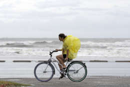 Emma Jewell rides her bicycle along Seawall Blvd. in Galveston, Texas as Hurricane Harvey intensifies in the Gulf of Mexico Friday, Aug. 25, 2017. Harvey is forecast to be a major hurricane when it makes landfall along the middle Texas coastline. (AP Photo/David J. Phillip)
