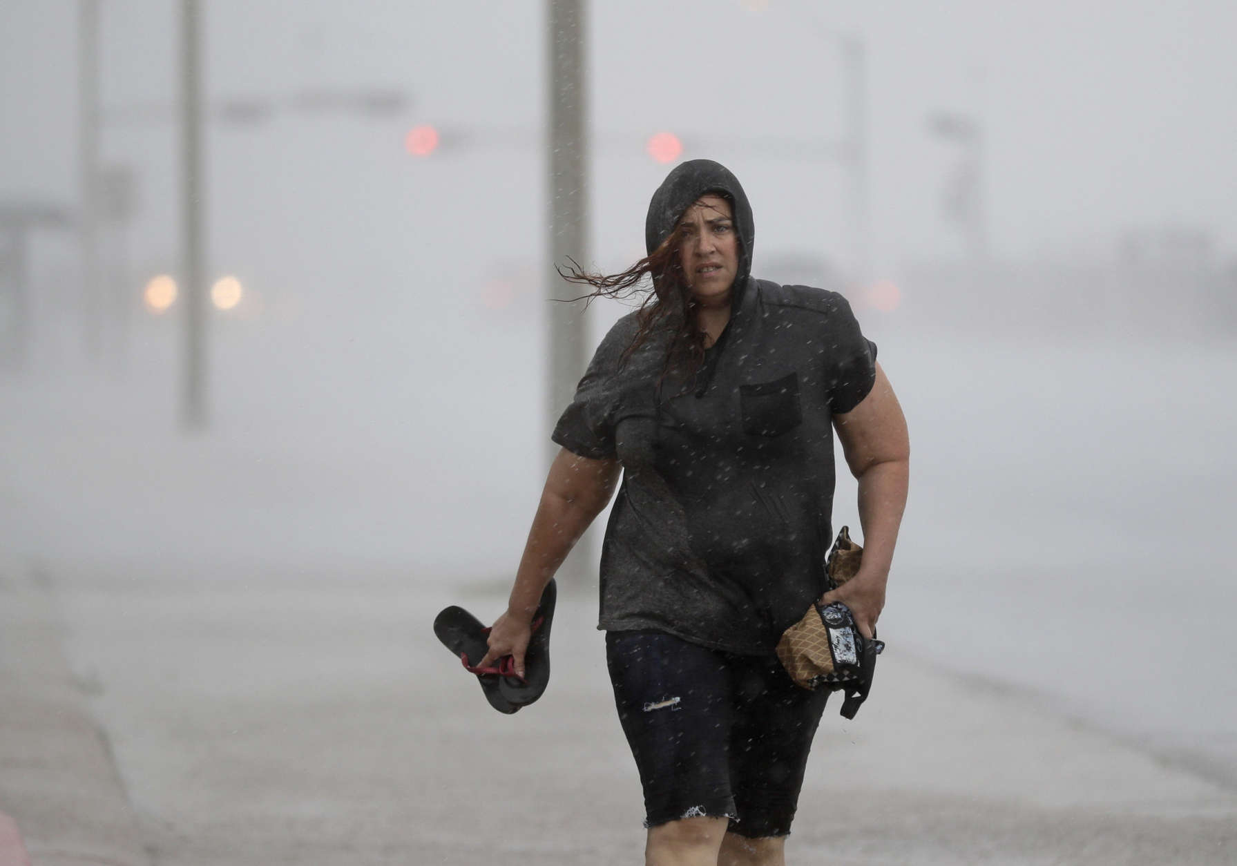 Hillary Lebeb walks along the seawall in Galveston, Texas as Hurricane Harvey intensifies in the Gulf of Mexico Friday, Aug. 25, 2017. Harvey is forecast to be a major hurricane when it makes landfall along the middle Texas coastline. (AP Photo/David J. Phillip)